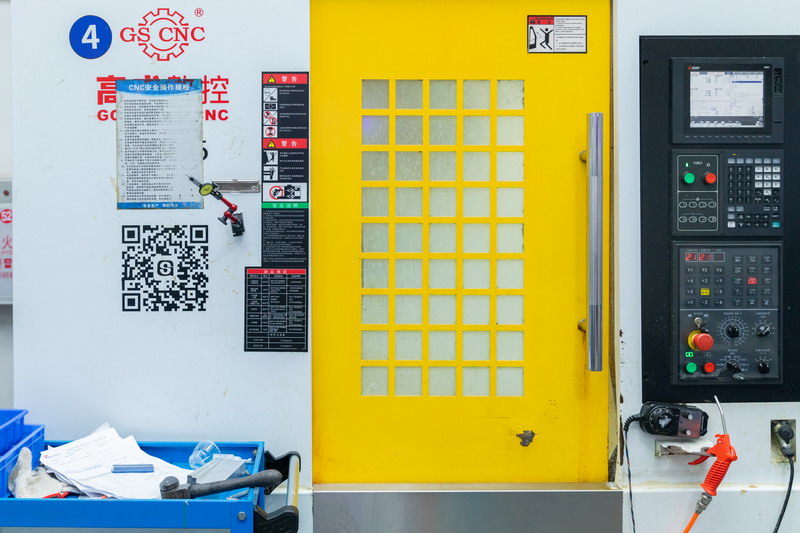 GS CNC enclosed vertical machining centre with bright yellow door and dark control panel