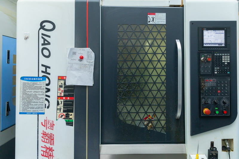 Qiao Hong enclosed vertical CNC machining centre with diamond mesh window door and grey control panel