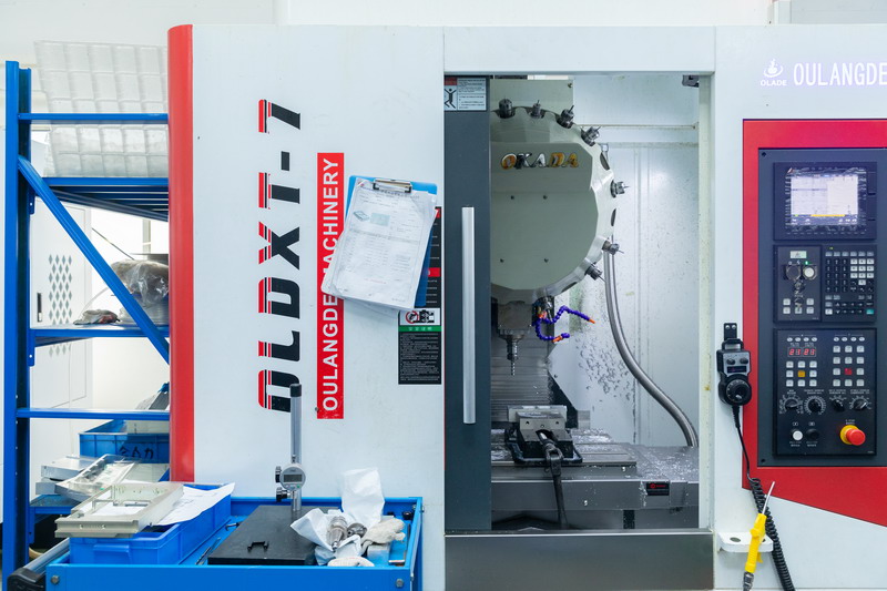 Oulangde vertical CNC machining centre with door open showing tool magazine spindle and vise